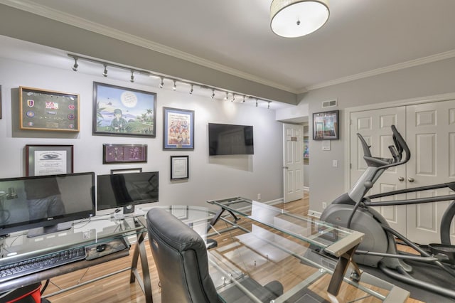 office area with ornamental molding, light wood-style flooring, visible vents, and baseboards