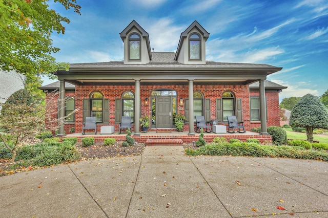 view of front of home with covered porch and brick siding