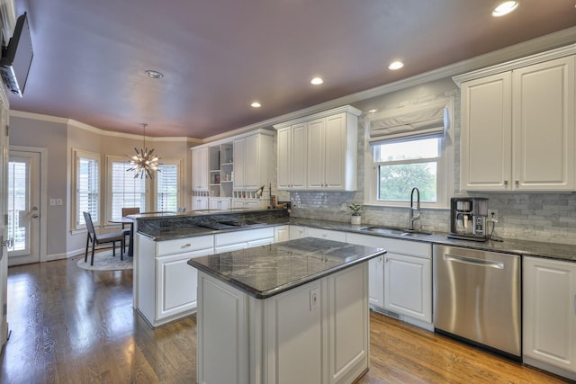 kitchen with sink, dishwasher, white cabinetry, hanging light fixtures, and a kitchen island