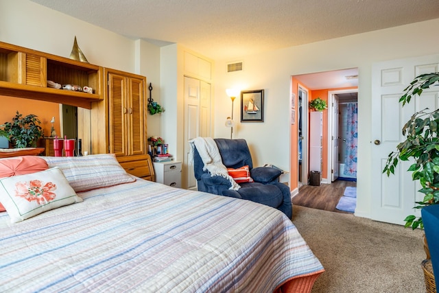 bedroom with dark colored carpet and a textured ceiling