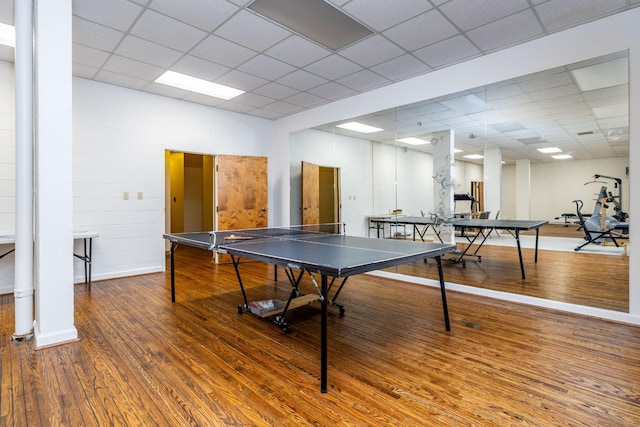 recreation room featuring a paneled ceiling and hardwood / wood-style floors