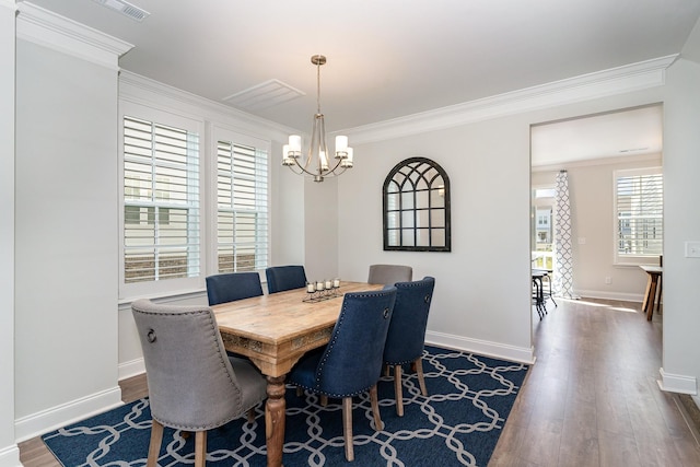 dining area featuring crown molding, dark hardwood / wood-style floors, and a chandelier