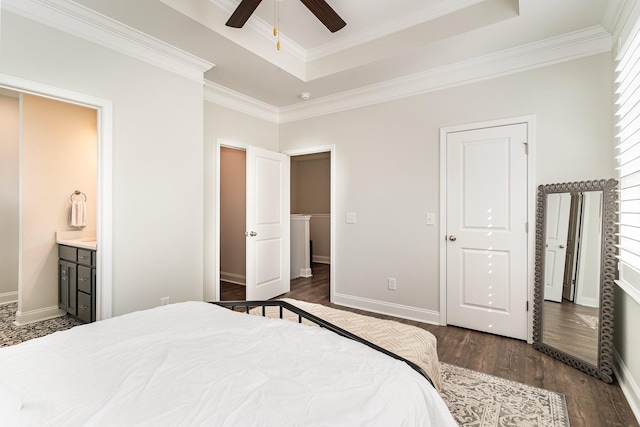 bedroom featuring dark hardwood / wood-style floors, connected bathroom, ceiling fan, a raised ceiling, and crown molding