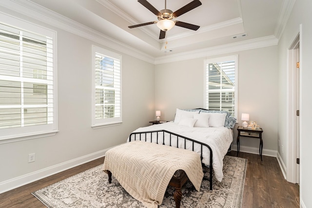 bedroom featuring a raised ceiling, ornamental molding, dark wood-type flooring, and ceiling fan