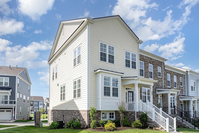 view of property with central AC unit and a front yard