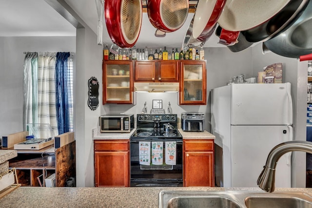 kitchen with white refrigerator, sink, and black / electric stove