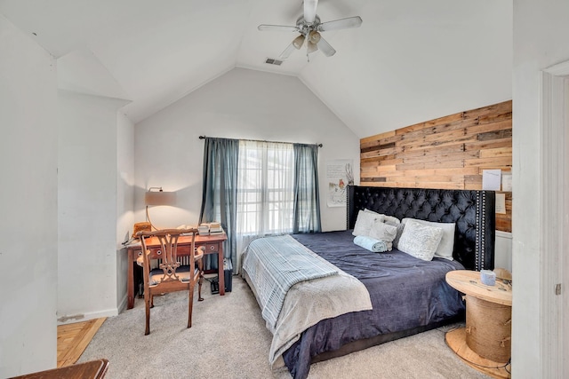 carpeted bedroom with vaulted ceiling, wooden walls, and ceiling fan