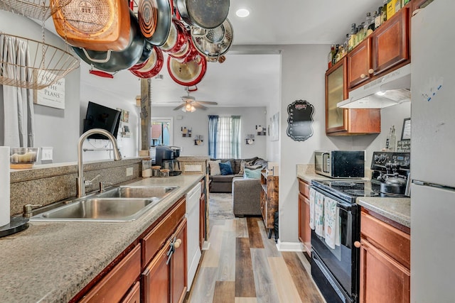 kitchen featuring ceiling fan, white appliances, sink, and light hardwood / wood-style flooring