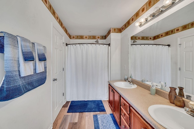 bathroom featuring wood-type flooring, vanity, and walk in shower