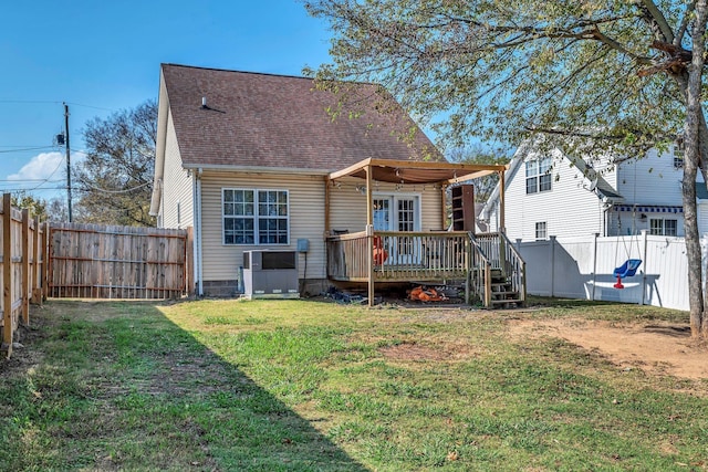 back of property featuring a wooden deck and a yard