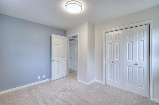 unfurnished bedroom featuring a closet and light carpet