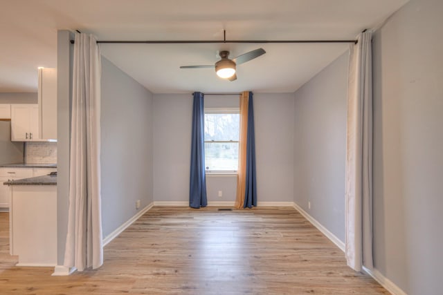 empty room with light hardwood / wood-style flooring and ceiling fan