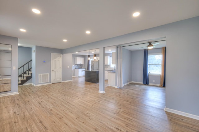 unfurnished living room featuring ceiling fan and light hardwood / wood-style flooring