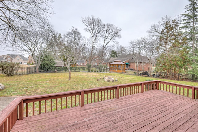 wooden terrace with a fire pit and a lawn