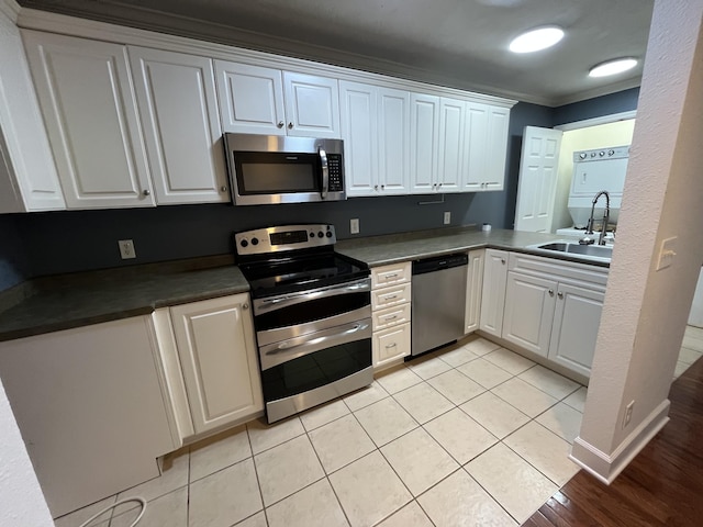 kitchen featuring crown molding, appliances with stainless steel finishes, sink, and white cabinets