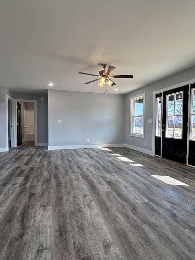 unfurnished living room featuring ceiling fan and dark hardwood / wood-style floors