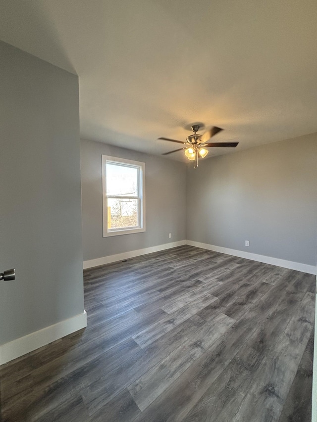 empty room with dark wood-type flooring and ceiling fan