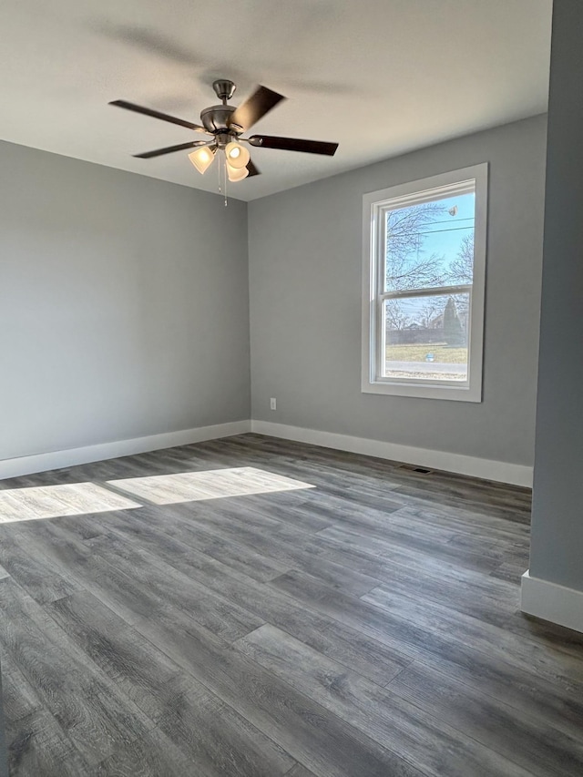 spare room featuring dark wood-type flooring and ceiling fan