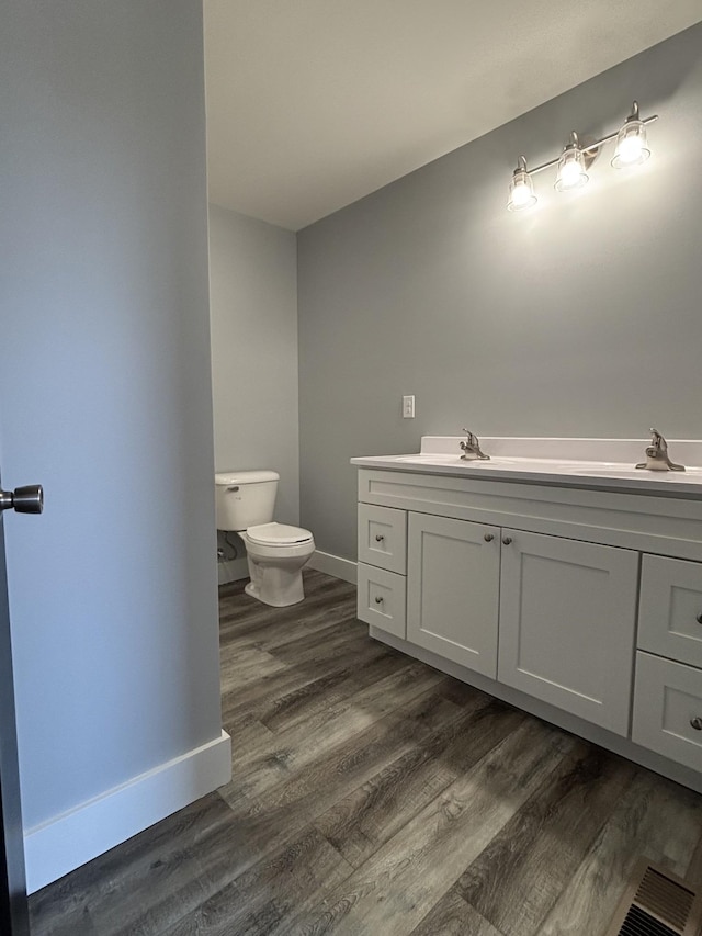 bathroom featuring vanity, hardwood / wood-style flooring, and toilet