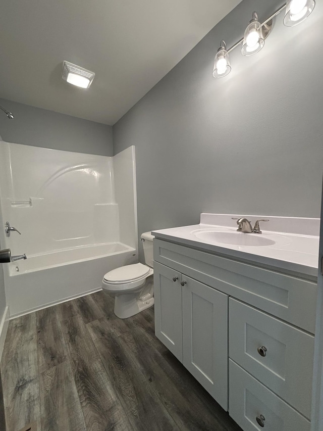 full bathroom with hardwood / wood-style flooring, vanity, bathtub / shower combination, and toilet