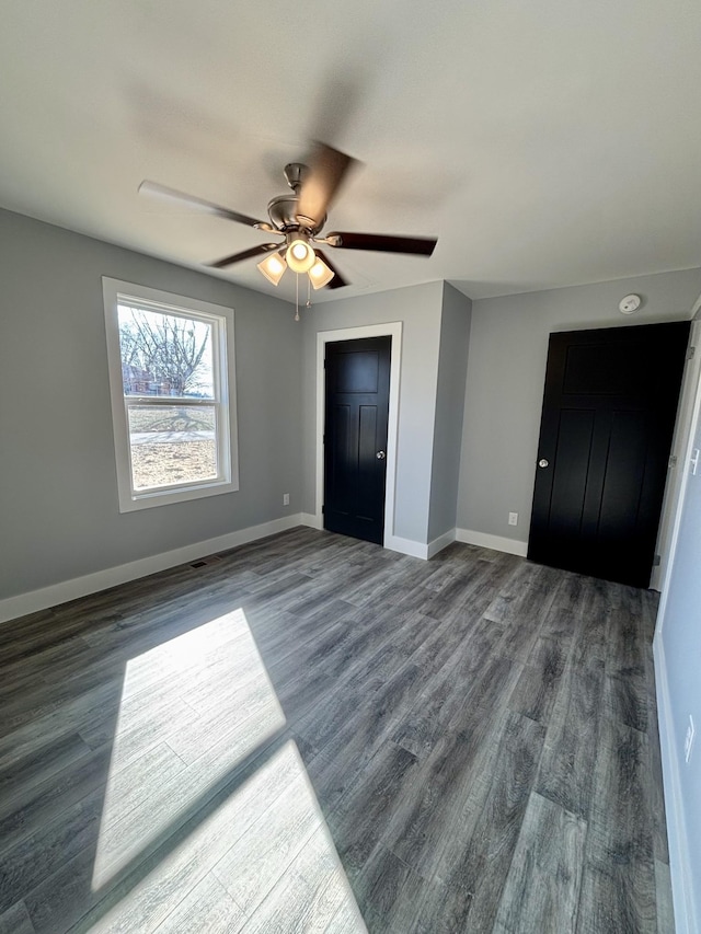 unfurnished bedroom with ceiling fan and dark hardwood / wood-style floors