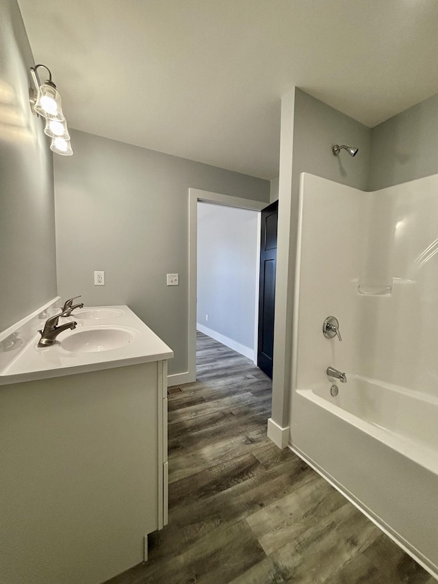 bathroom with vanity, wood-type flooring, and  shower combination