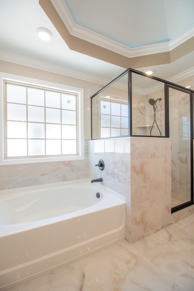 bathroom featuring ornamental molding and shower with separate bathtub