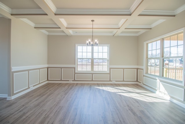 unfurnished room featuring beam ceiling, light wood-type flooring, and a wealth of natural light