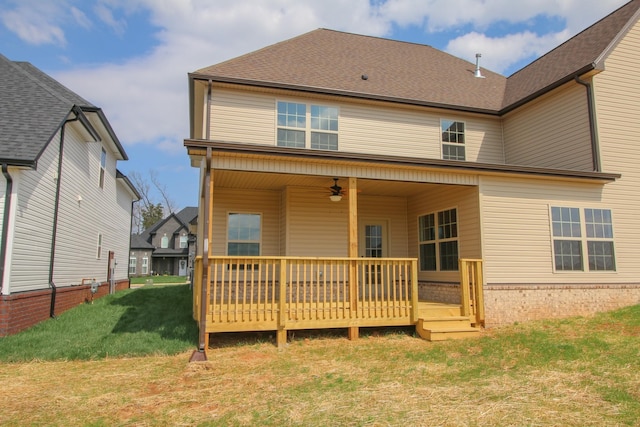 back of property featuring a deck, ceiling fan, and a lawn