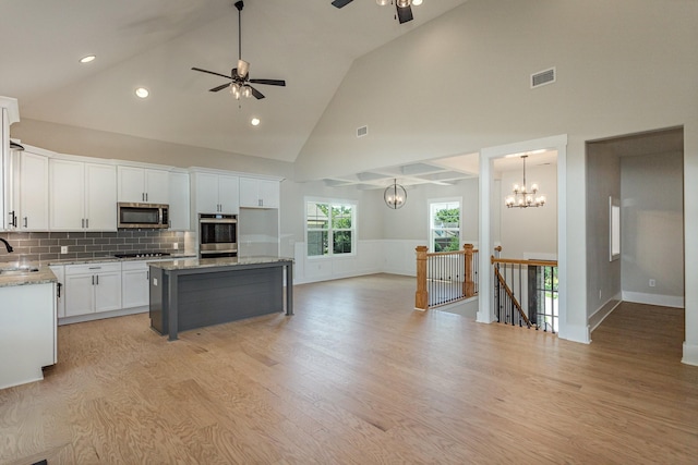 kitchen featuring stainless steel appliances, a center island, sink, and white cabinets