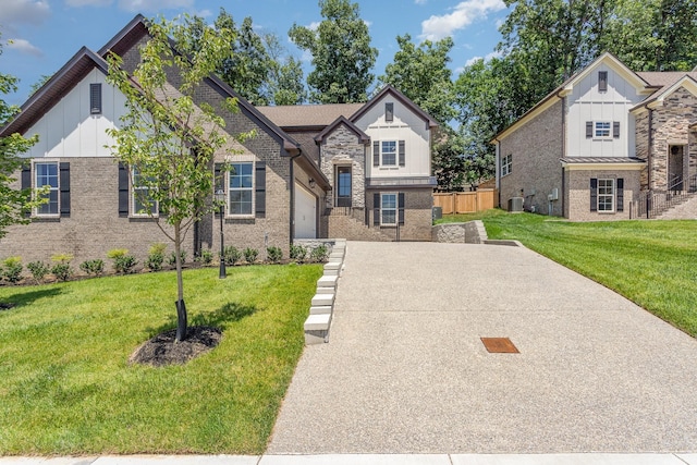 view of front of house with central AC, a garage, and a front lawn