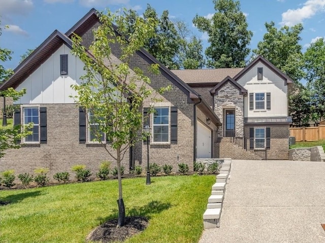 view of front of house with concrete driveway, brick siding, a front lawn, and board and batten siding