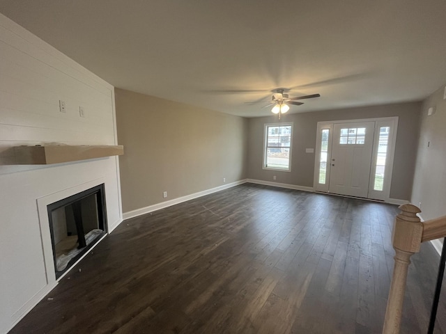 unfurnished living room featuring ceiling fan and dark hardwood / wood-style floors