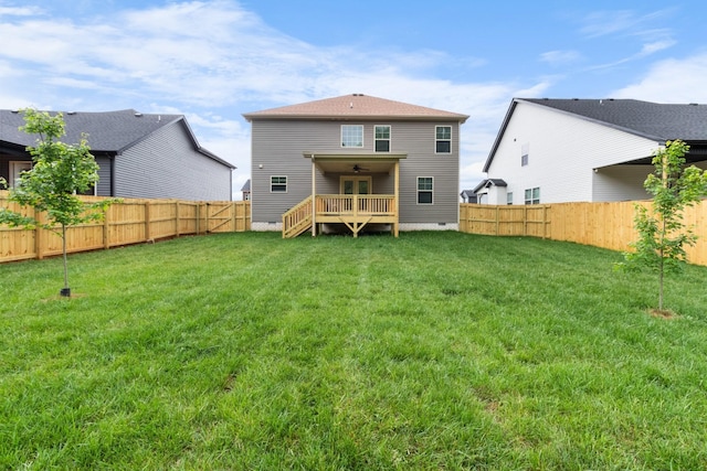 back of house with a wooden deck and a lawn