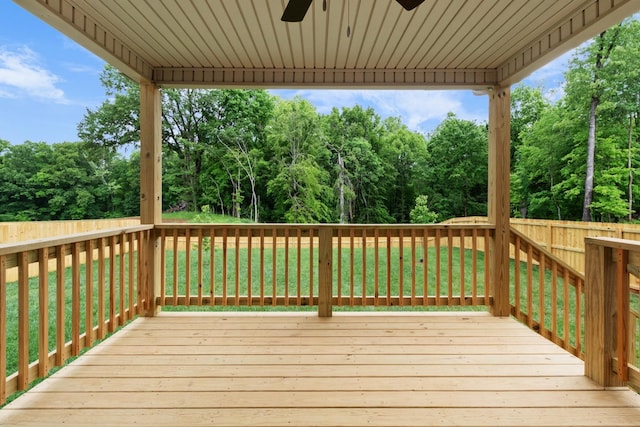 wooden deck featuring ceiling fan and a lawn