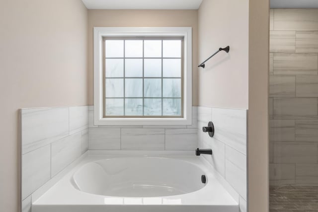 bathroom with plenty of natural light and a bath