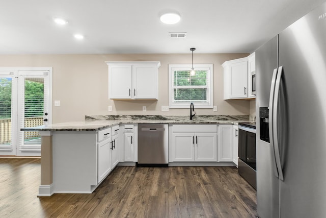 kitchen featuring sink, appliances with stainless steel finishes, white cabinets, decorative light fixtures, and kitchen peninsula