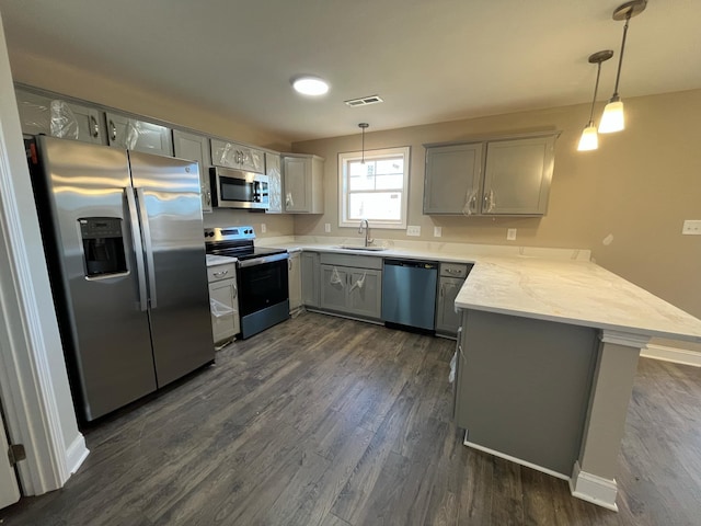 kitchen with pendant lighting, appliances with stainless steel finishes, gray cabinets, and kitchen peninsula