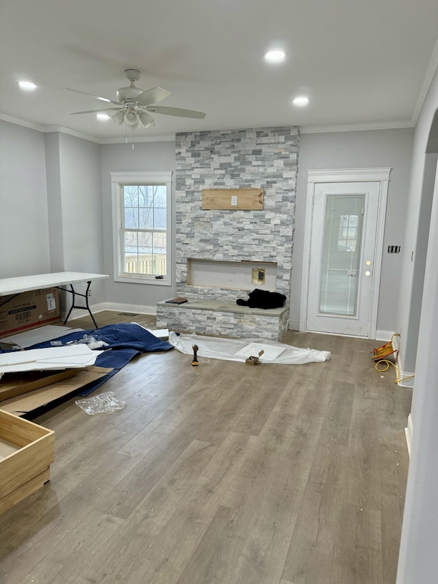 living room with crown molding, ceiling fan, and light hardwood / wood-style flooring