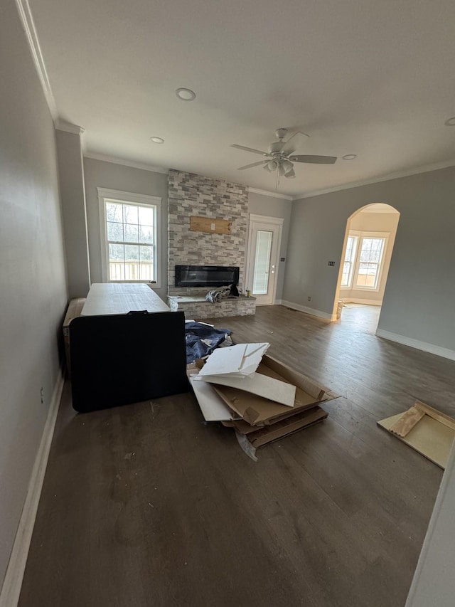 living room featuring dark hardwood / wood-style flooring, crown molding, a fireplace, and ceiling fan