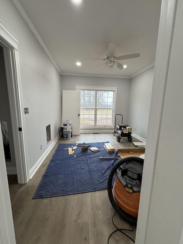 exercise room featuring crown molding, dark hardwood / wood-style floors, and ceiling fan