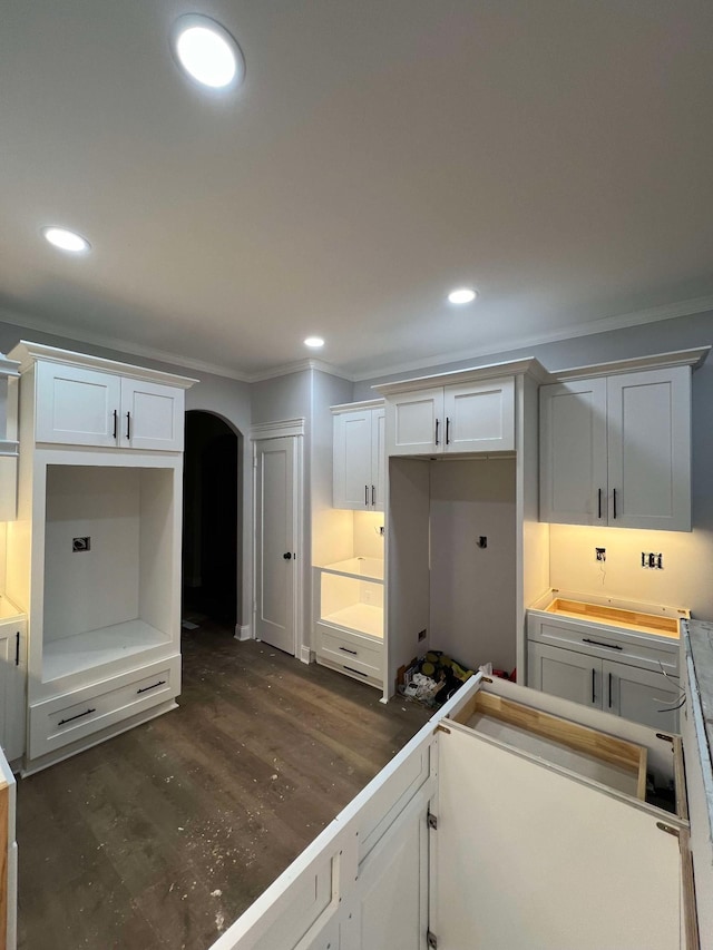 kitchen featuring white cabinetry, ornamental molding, and dark hardwood / wood-style flooring