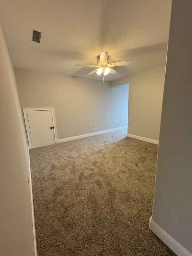 unfurnished room with ceiling fan and carpet