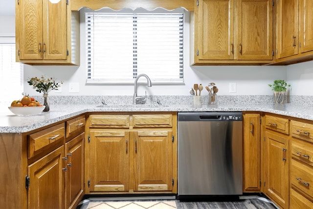 kitchen featuring light stone counters, sink, and stainless steel dishwasher