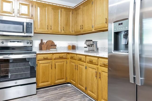 kitchen with hardwood / wood-style floors and stainless steel appliances