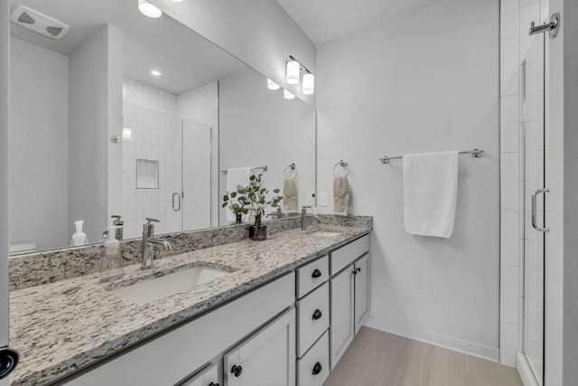 bathroom with vanity, a shower with door, and wood-type flooring