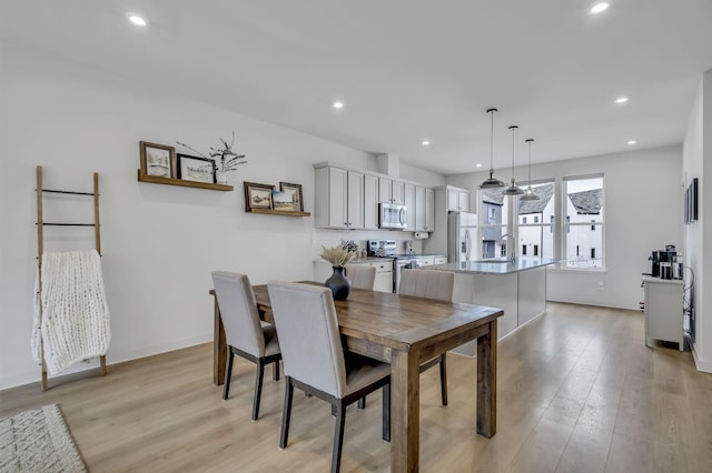 dining space with sink and light hardwood / wood-style flooring