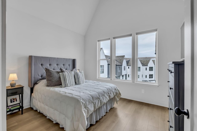 bedroom with lofted ceiling and light hardwood / wood-style flooring