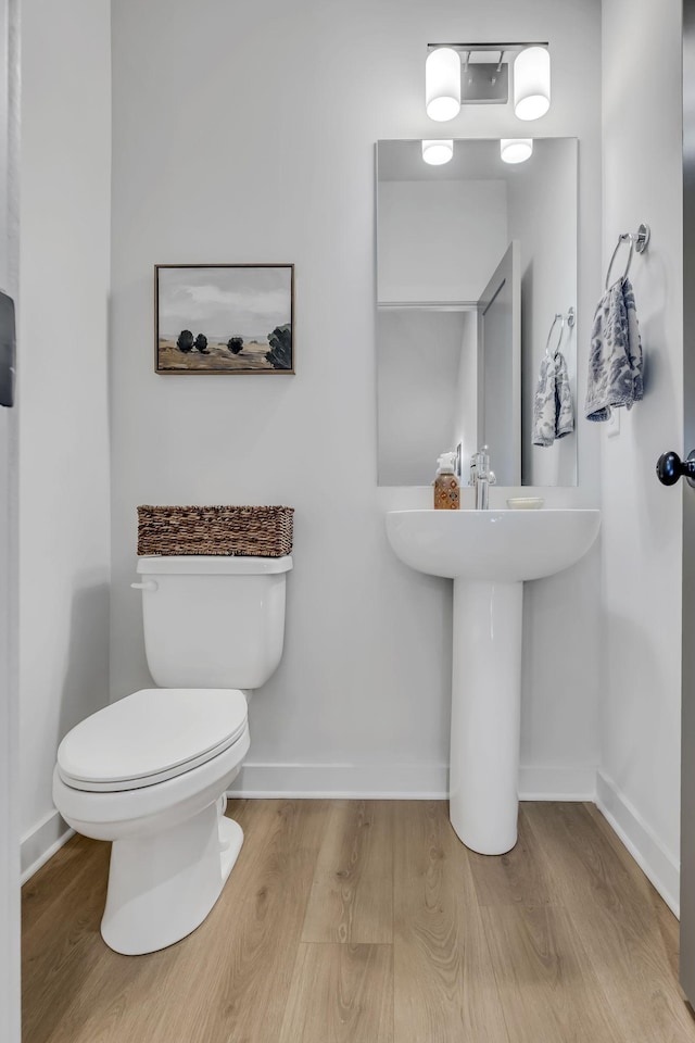 bathroom featuring wood-type flooring and toilet