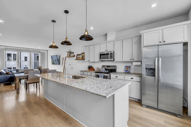 kitchen with stainless steel appliances, white cabinetry, and sink